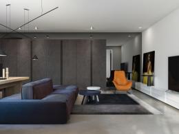 Интерьер гостиной с оранжевым креслом и синим диваном