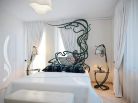 Эксклюзивный дизайн спальни в белом цвете Эксклюзивность дизайну спальни придает оригинальная кровать в стиле арт-нуво. Она выделяется на белом фоне стен и штор на окнах  которые тоже белого цвета.
