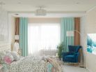 Интерьер спальни в стиле модерн Интерьер спальни в стиле модерн с ярким синим креслом и прямыми шторами.