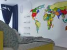 Стена белого цвета с цветной картой мира в детской комнате Очень красиво и с учетом увлечений декорирована стена в детской комнате - на ней яркая цветная карта мира.
